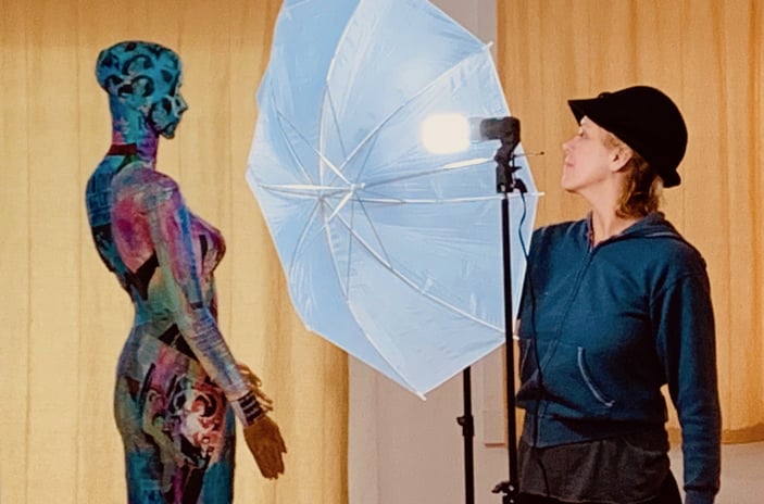 Annie Wood faces one of her painted mannequins with photo umbrella in background