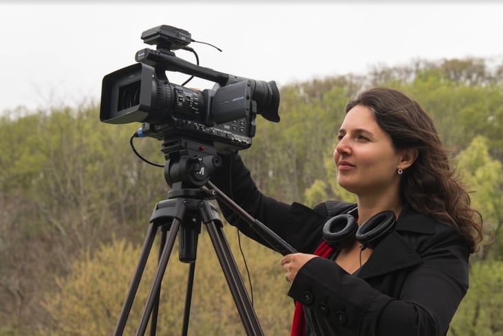 Arielle Nóbile standing behind a movie camera