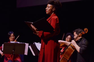 A woman in red dress with lectern on stage