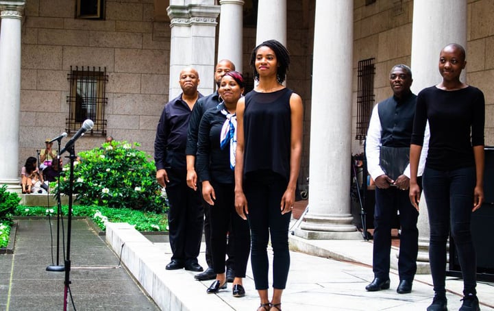 Performer standing in formation dressed in black