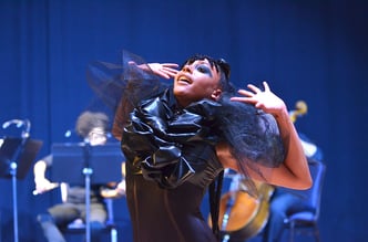 A performer on stage with blue background