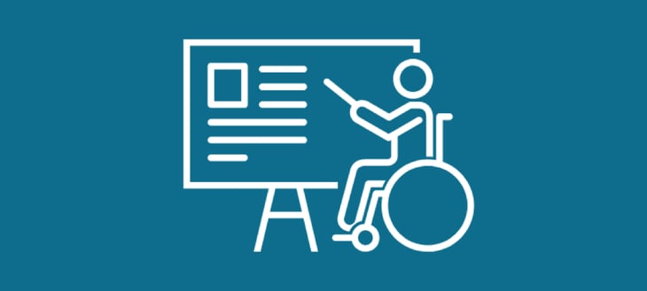 A person in a wheelchair teaching and pointing at information on a board