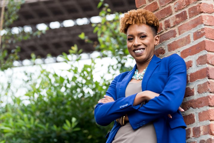 Candace Thompson-Zachery in blue blazer, smiling with arms folded