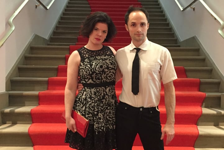 Susie Williams and Terry Crane stand in front of a stairway with red carpet