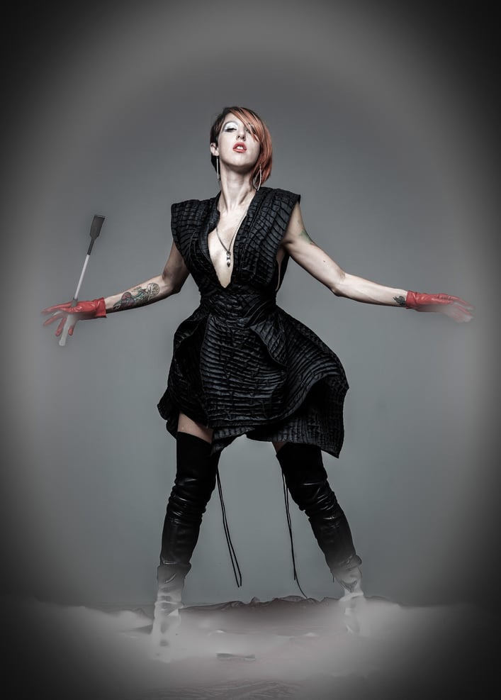 Agatha in dance pose with black outfit and grey background