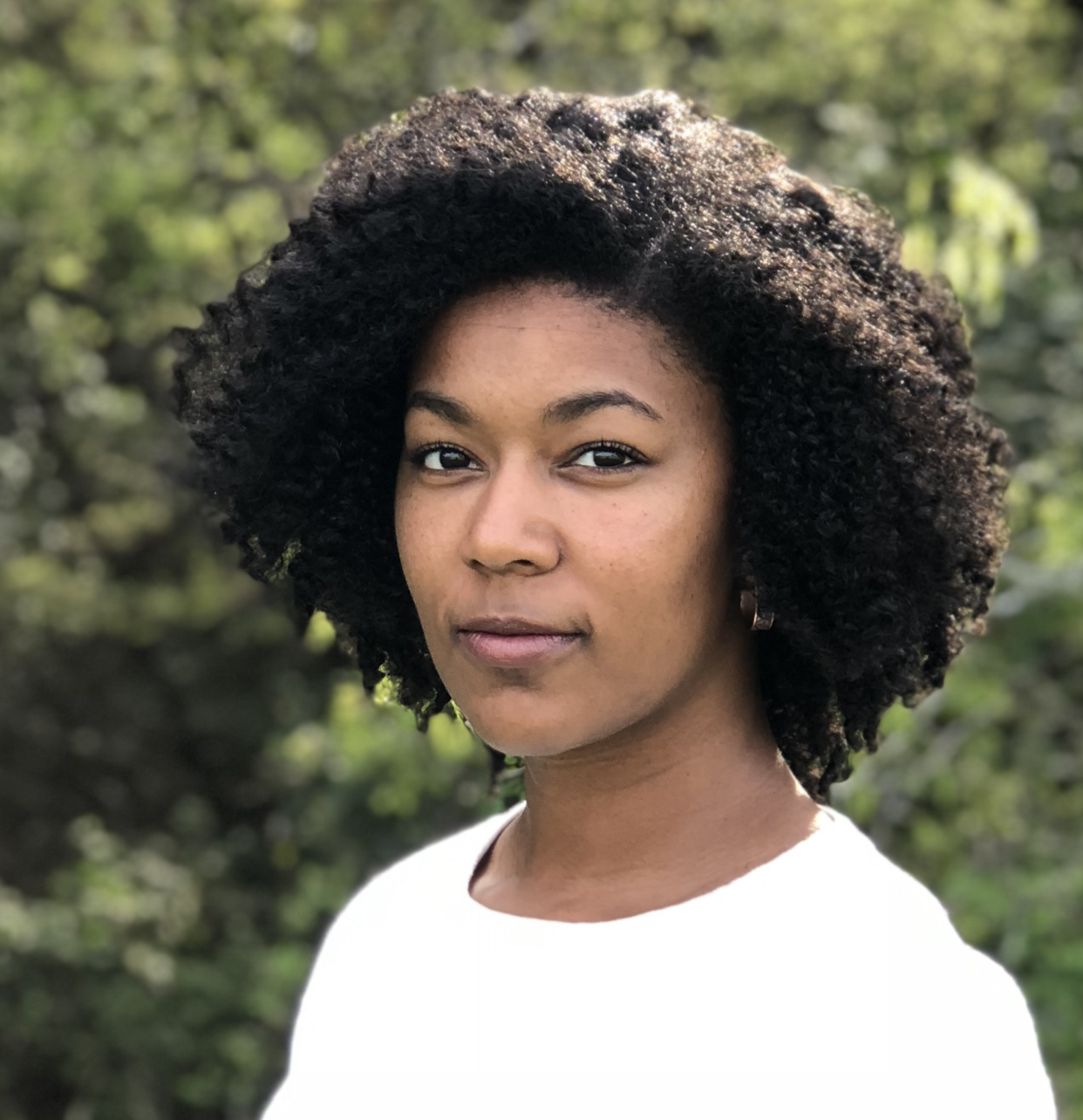 Simone Alexander with curly black hair in a white t-shirt