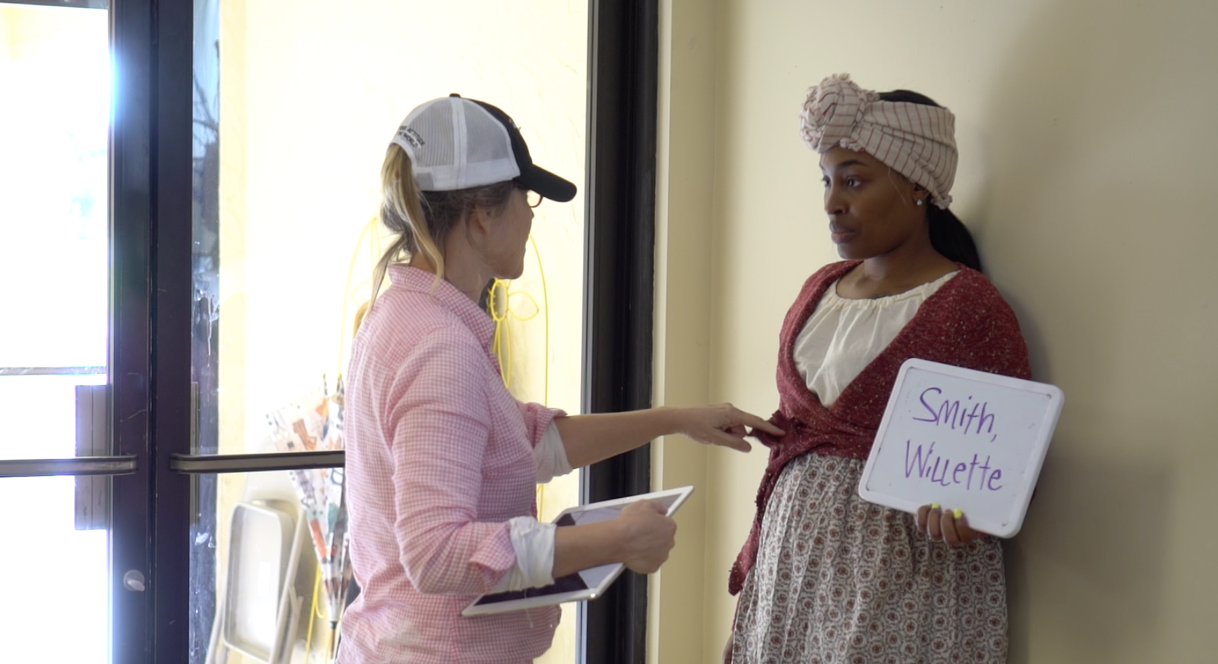 Project costume designer performing a fitting on woman re-enactor participant