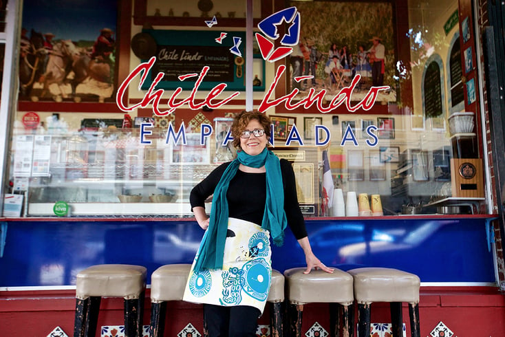 Paula Tejada of Cine Chileno and Chile Lindo smiling in front of her restaurant