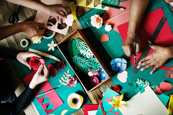 People cutting crafts to make holiday ornaments.